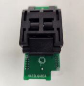 A black electronic component mounted on a small green circuit board.