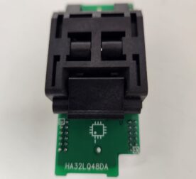 A black electronic component mounted on a small green circuit board.