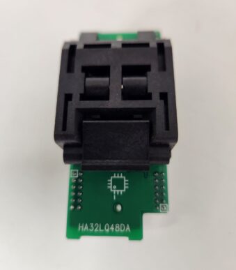A black electronic component mounted on a small green circuit board.